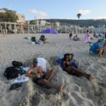 People sunbathe at the beach in Israel's northern coastal city of Haifa on Sunday, despite fears of an attack by Iran and Hezbollah