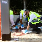 Israeli first responders scrub blood stains at the scene of a reported stabbing attack near Tel Aviv