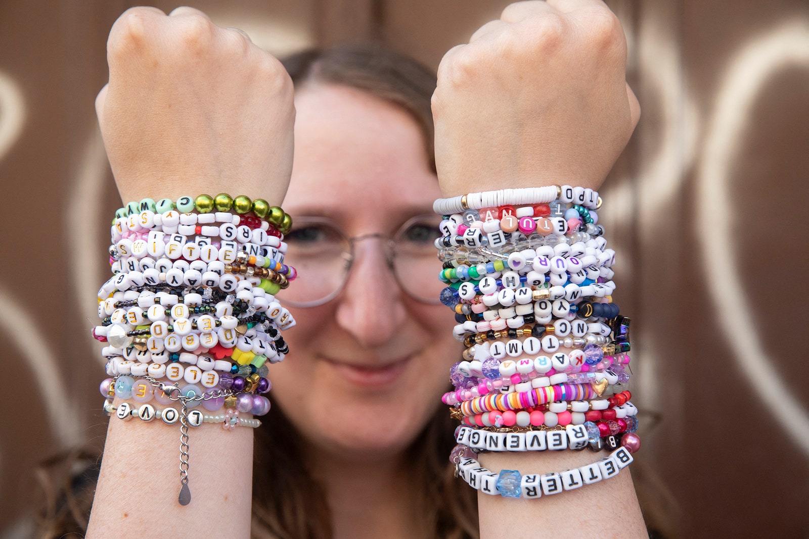 A young person with wrists full of bracelts.