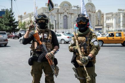 Taliban security personnel stand guard along a Kabul road on the eve of the third anniversary of Taliban takeover of Afghanistan