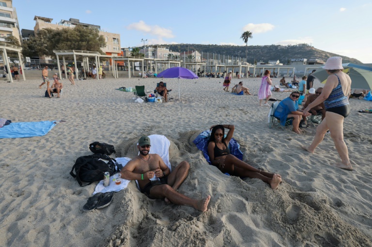 People sunbathe at the beach in Israel's northern coastal city of Haifa despite fears of an attack by Iran and Hezbollah