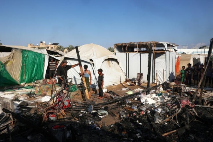 The aftermath of an overnight strike that hit tents used as temporary shelters by displaced Palestinians in central Gaza