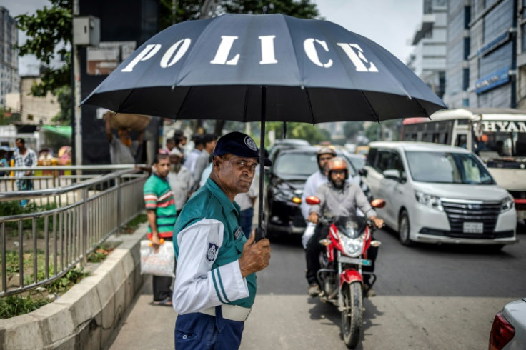 A Bangladeshi police officer directs traffic; the force had gone on strike in the wake of the ouster of the premier, fearing attacks against themselves, but have since resumed their duties