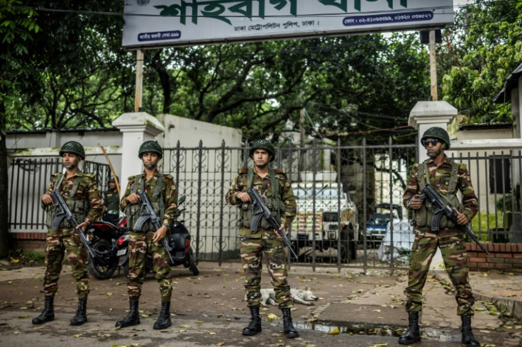 Bangladeshi soldiers guard an empty police station in Dhaka; the army is held in higher public regard than the police for opting not to forcibly quell the protests