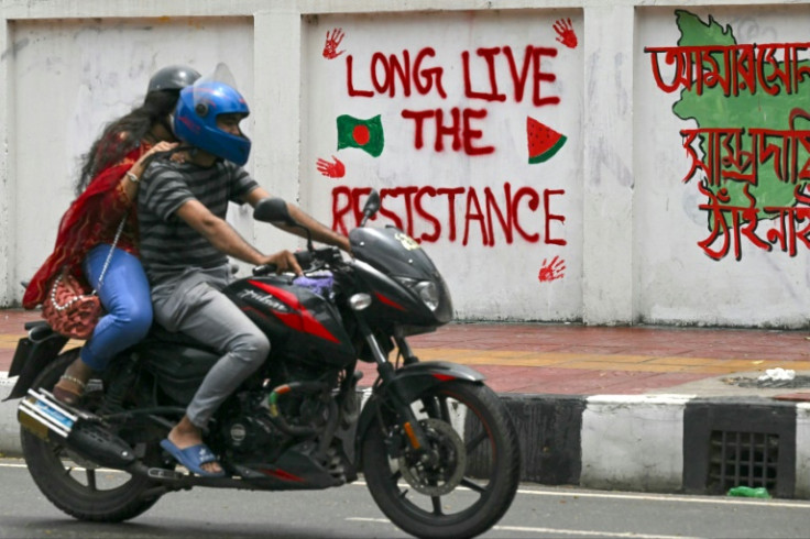 A couple rides past a wall mural that supports the student uprising: Sheikh Hasina fled to neighbouring India on Monday as protesters flooded Dhaka's streets in a dramatic end to her 15-year rule