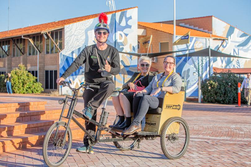 Samual Cullen, Rebecca Prain and Kate Frost on a tricycle.