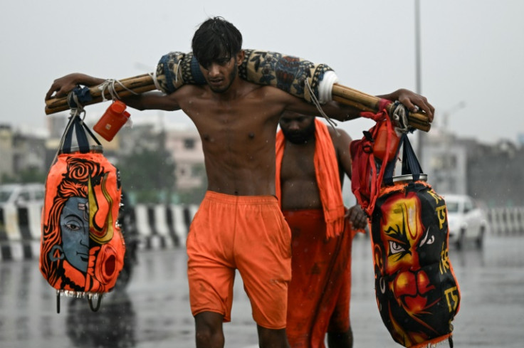 Kanwariyas, devotees of the Hindu deity Shiva, carry holy water from the river Ganges during their ritualistic trek