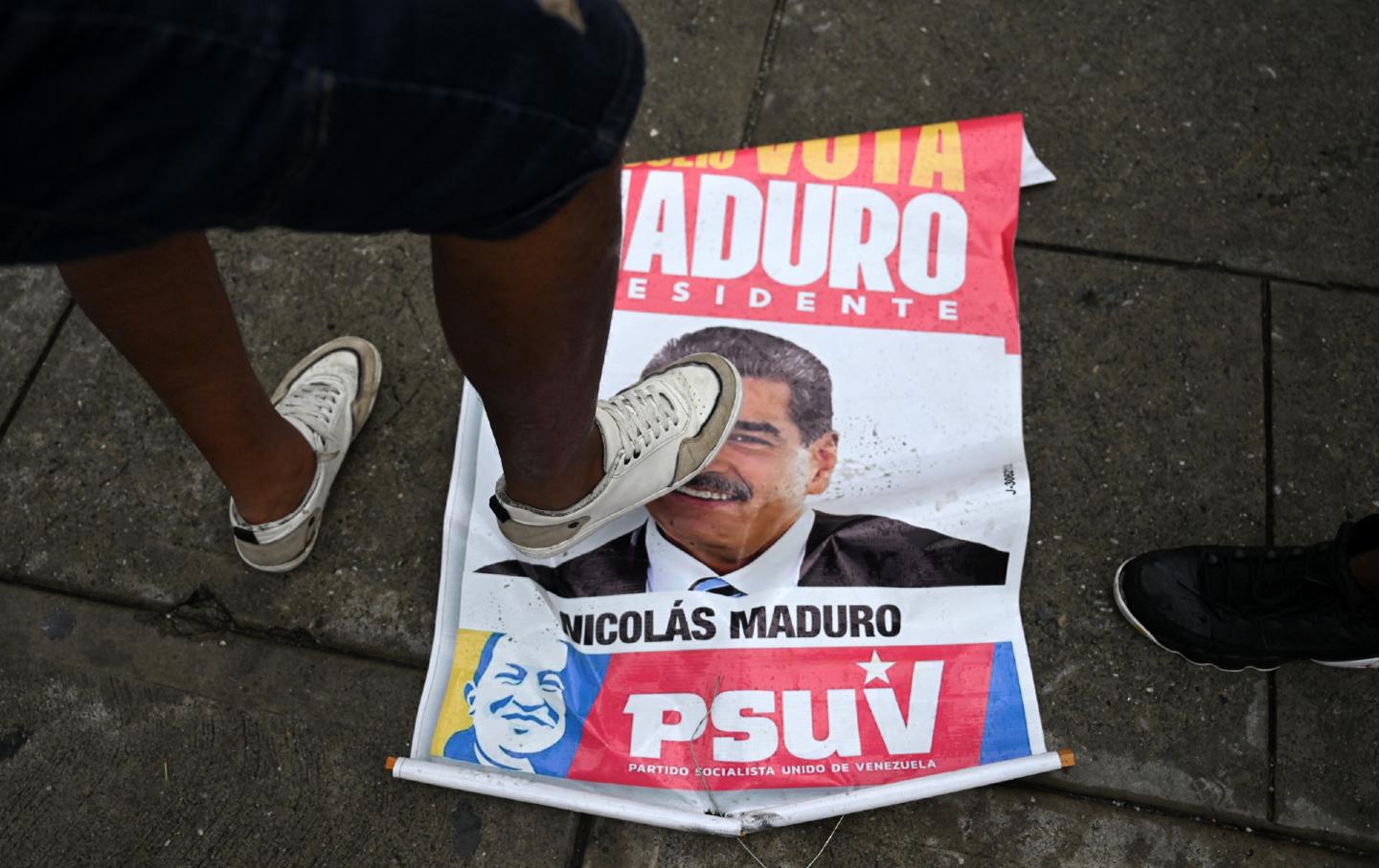 An opponent of Venezuelan President Nicolas Maduro's government steps on an election campaign poster with the image of Maduro during a protest at the Petare neighborhood in Caracas on July 29, 2024, a day after the Venezuelan presidential election.