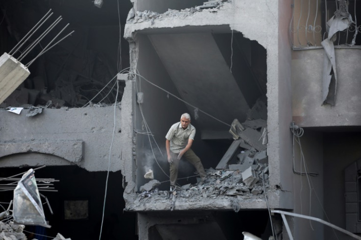 A man clears rubble from a  building hit during Israeli bombardment in Nuseirat on August 12, 2024