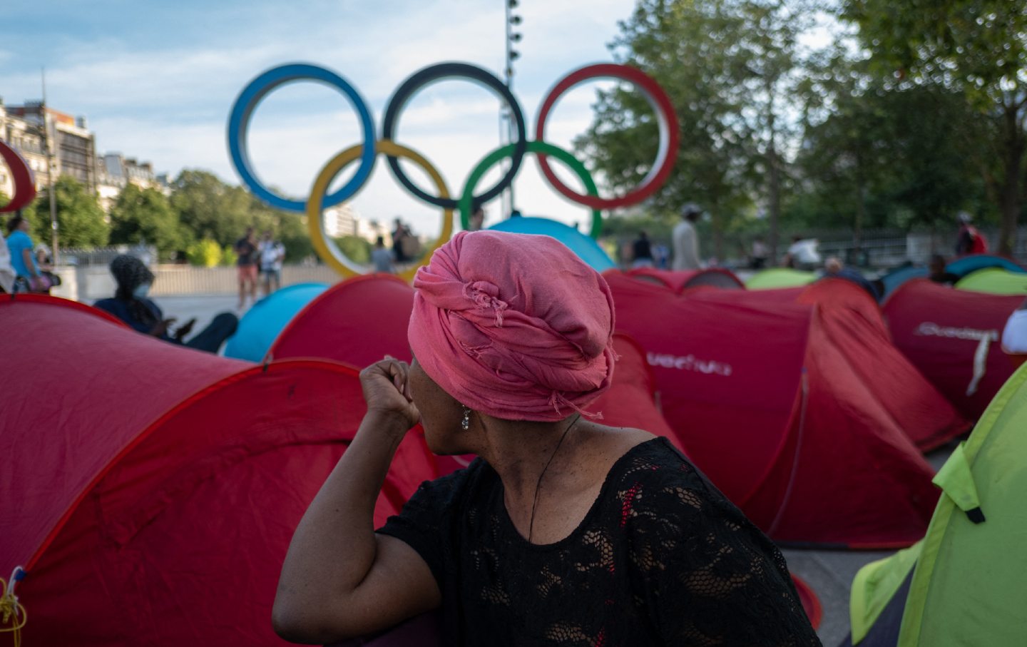 A women seated during the installation of an encampment at the Bastille to demand accommodation for homeless people in Paris on August 6, 2024.