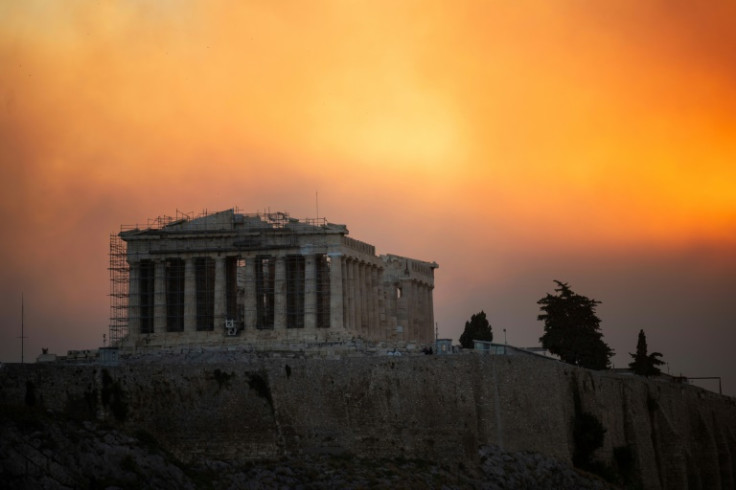 The Parthenon temple atop the Acropolis hill in a cloud of smoke from a wildfire threatening the Athens suburbs