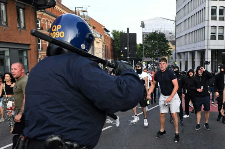 Riot police face protestors in Bristol, southern England, during a demonstration held in reaction to the fatal stabbings in Southport