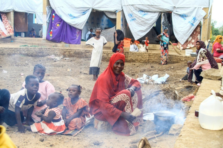 A woman cooks at a camp for people displaced by foods in Sudan's eastern city of Kassala