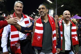 Adam Goodes at SCG with 2005 Sydney Swans premiership teammates holding the cup and greeting fans.