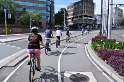 Cyclists riding through Sydney streets on a sunny day