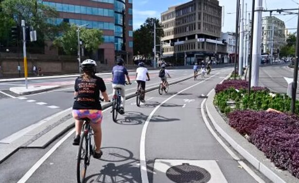 Cyclists riding through Sydney streets on a sunny day