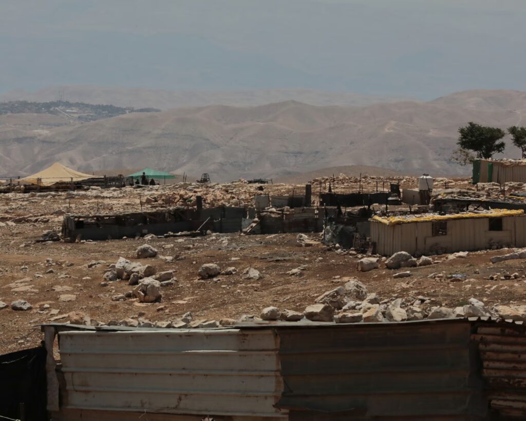 A Palestinian Bedouin community with an illegal Israeli settler outpost visible in the distance in Mughayyir al-Deir.