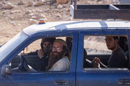 Israeli settlers drive a pickup truck at an illegal outpost near the Palestinian village of Mughayyir al-Deir.