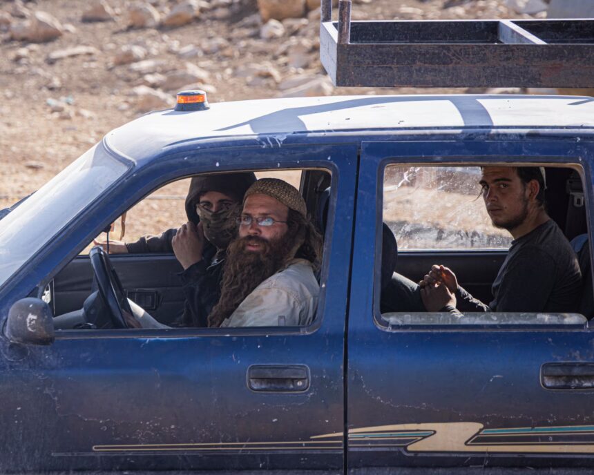 Israeli settlers drive a pickup truck at an illegal outpost near the Palestinian village of Mughayyir al-Deir.