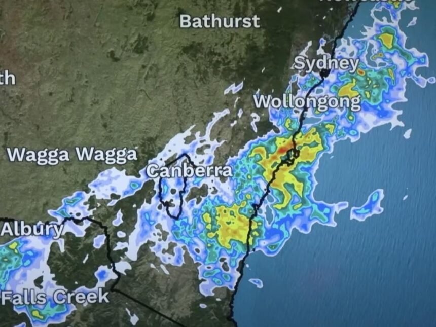 Digital weather forecast screen showing multi-day outlook with temperature highs and lows, rainfall predictions, and animated icons for sun, clouds, and storms across Sydney and surrounding regions.