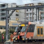 Transport workers assisting commuters off stranded Sydney train