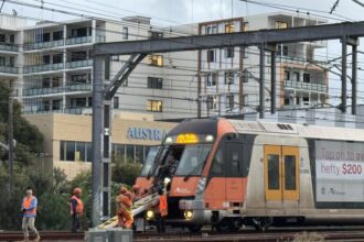 Transport workers assisting commuters off stranded Sydney train