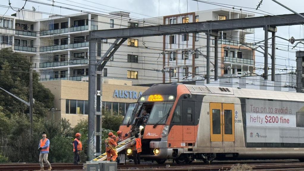 Transport workers assisting commuters off stranded Sydney train