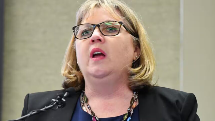 Australian Education Union president speaking at a lectern during a press conference on Gaza conflict guidelines.