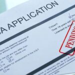 Overwhelmed tribunal worker surrounded by visa application files